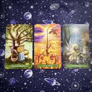 Three tarot cards, the Queen of Pentacles, Ace of Wands, and the Star